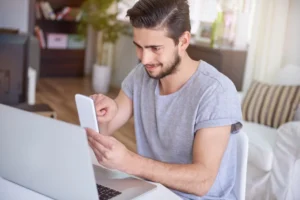 hombre viendo en mobile y desktop qué debe tener una página web profesional en 2026